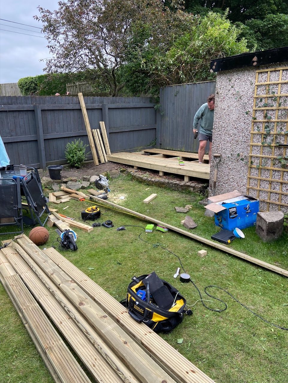 Decking build in progress — timber and tools laid out on the lawn.