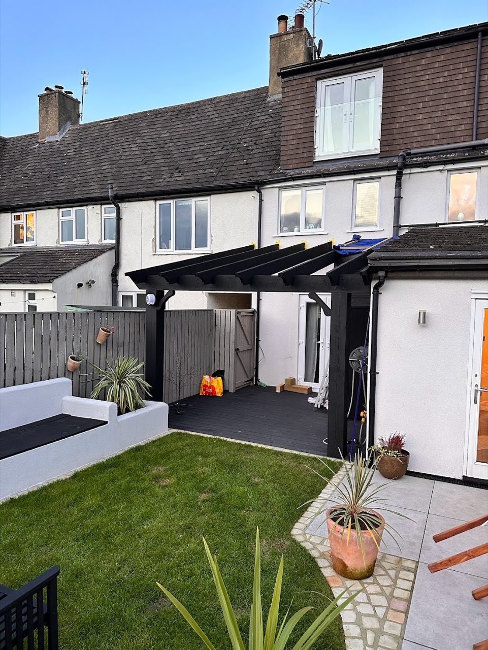 The same garden with a new black pergola over the patio.